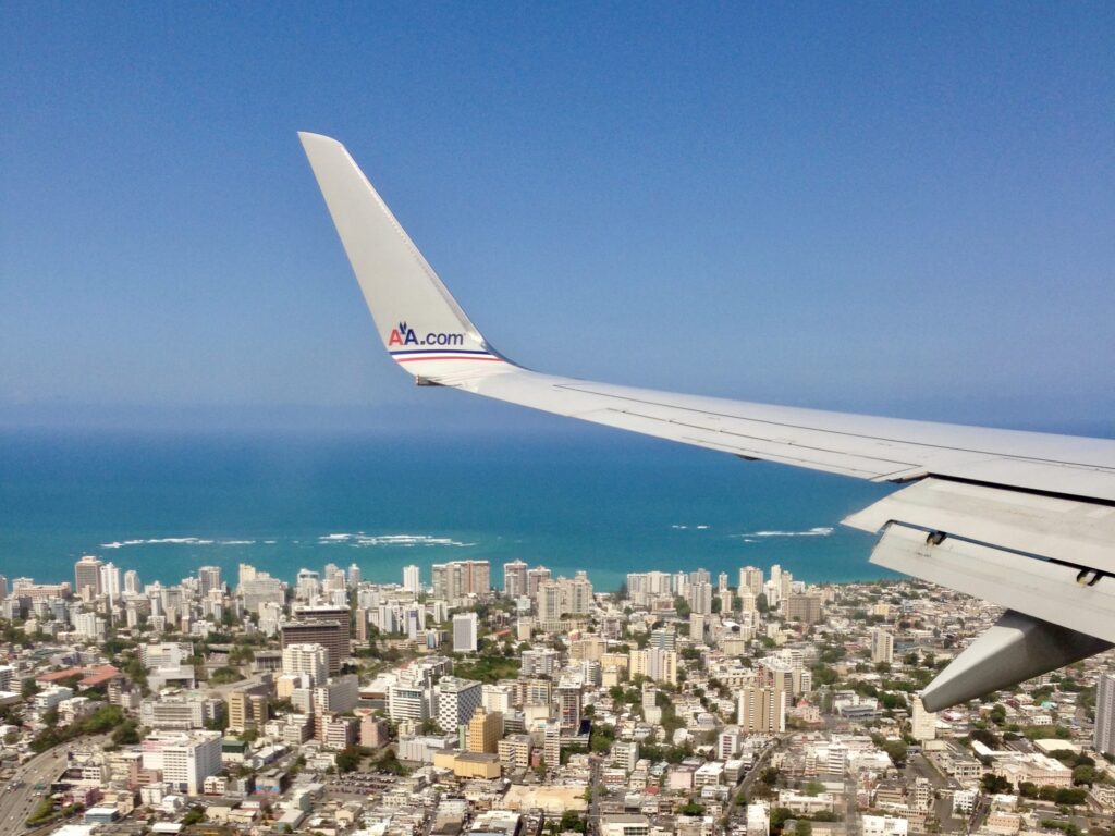 An American Airlines plane flying over San Juan, Puerto Rico.