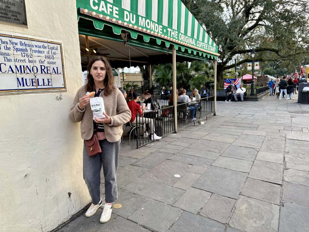 Irina standing with beignets in front of the Café Du Monde, New Orleans